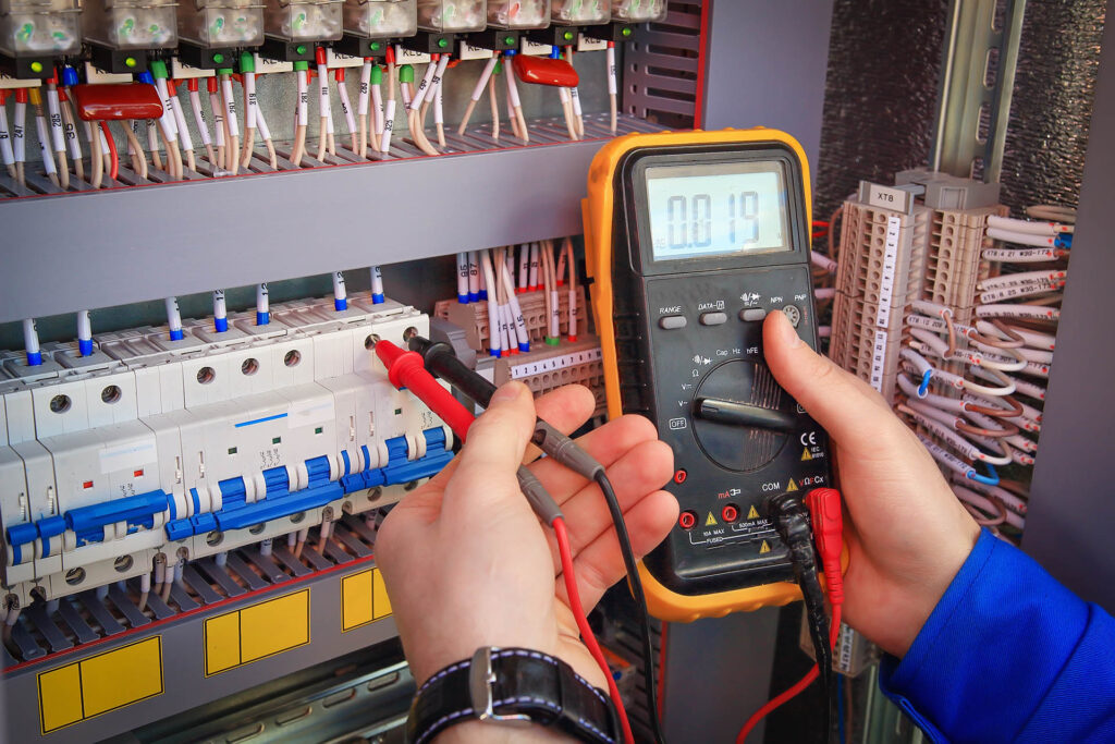 Multimeter,Is,In,Hands,Of,Electrician,On,Background,Of,Electrical